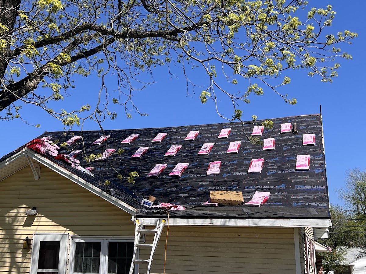 New shingles being laid across a house roof
